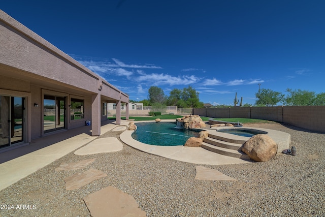 view of swimming pool featuring a fenced in pool, a fenced backyard, a patio, and an in ground hot tub