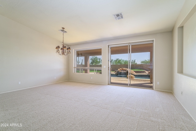 carpeted spare room featuring lofted ceiling, baseboards, visible vents, and a notable chandelier