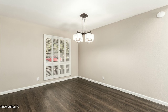 unfurnished dining area with dark hardwood / wood-style flooring and a chandelier