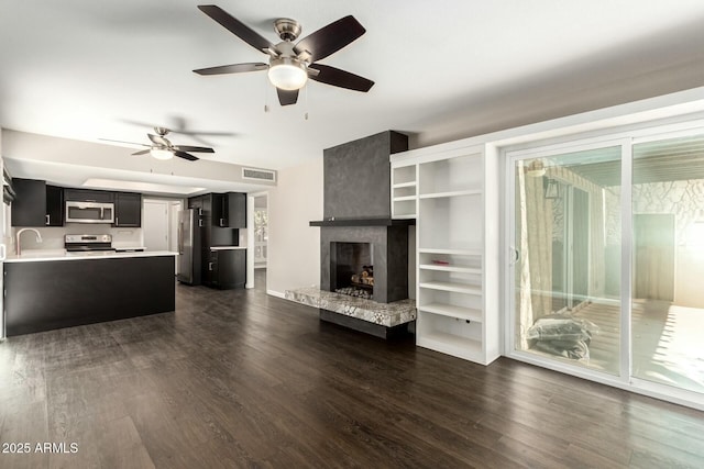 unfurnished living room with dark hardwood / wood-style flooring, sink, and a fireplace