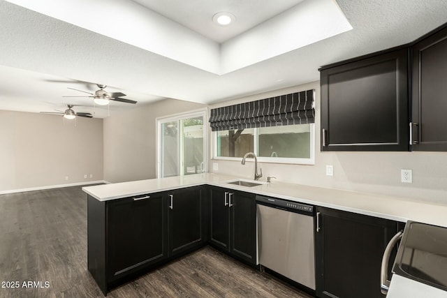 kitchen featuring sink, stove, dark hardwood / wood-style floors, stainless steel dishwasher, and kitchen peninsula