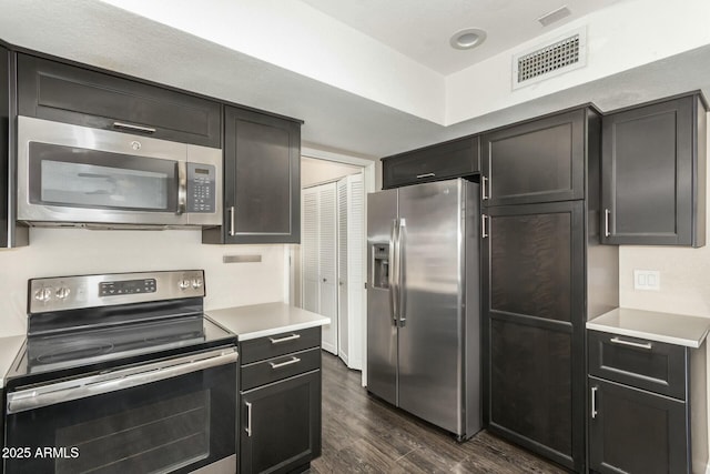 kitchen with appliances with stainless steel finishes and dark hardwood / wood-style flooring