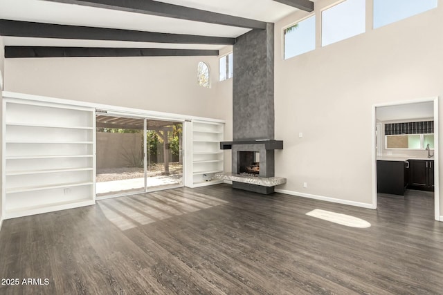 unfurnished living room with a fireplace, dark hardwood / wood-style flooring, sink, and a wealth of natural light