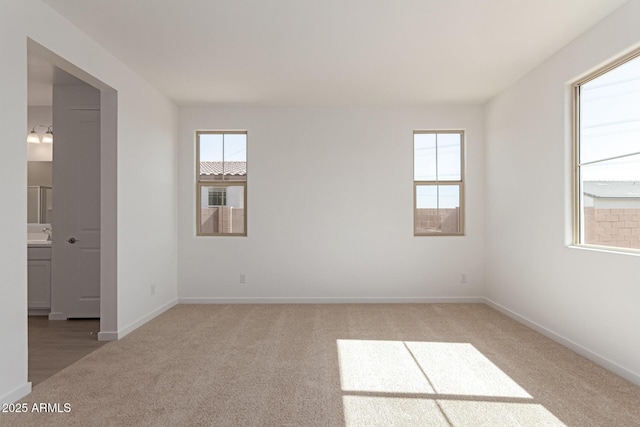 spare room featuring carpet and baseboards