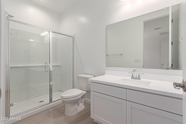 full bathroom with visible vents, toilet, a stall shower, vanity, and wood finished floors