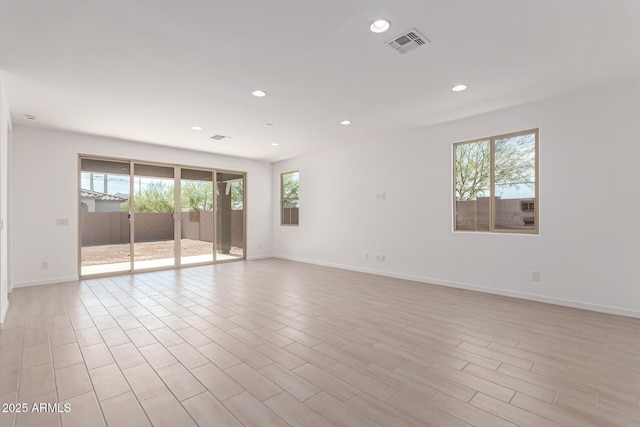 unfurnished room featuring light wood-type flooring, baseboards, visible vents, and recessed lighting