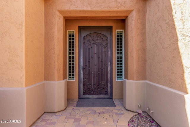 view of exterior entry featuring stucco siding