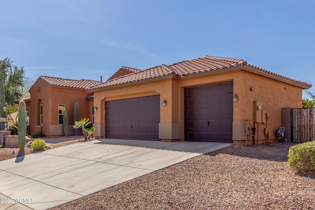 mediterranean / spanish-style home featuring a garage, a tile roof, and stucco siding