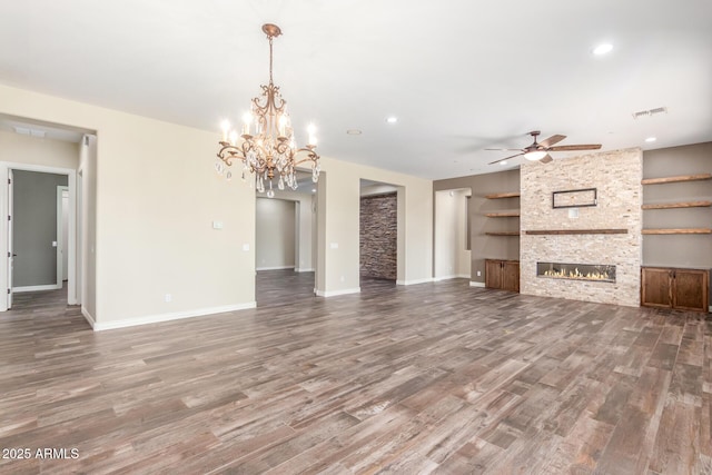 unfurnished living room with ceiling fan, a fireplace, baseboards, and wood finished floors