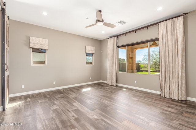 unfurnished room featuring recessed lighting, visible vents, a ceiling fan, wood finished floors, and baseboards