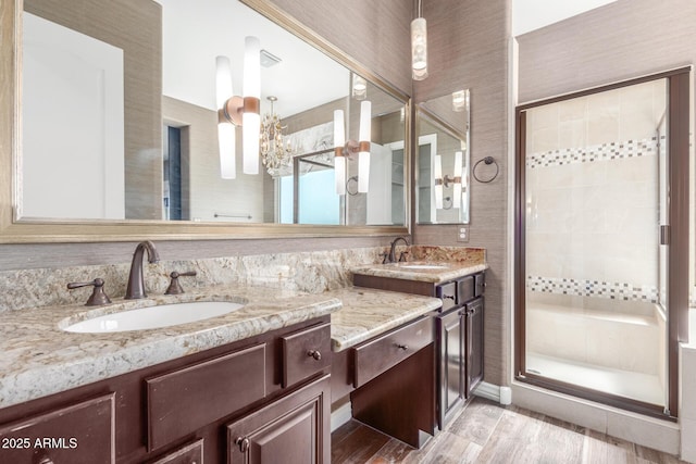 full bathroom with a stall shower, wood finished floors, and vanity