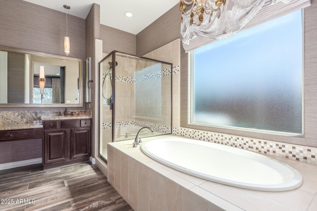 full bathroom with a garden tub, a shower stall, wood finished floors, and vanity