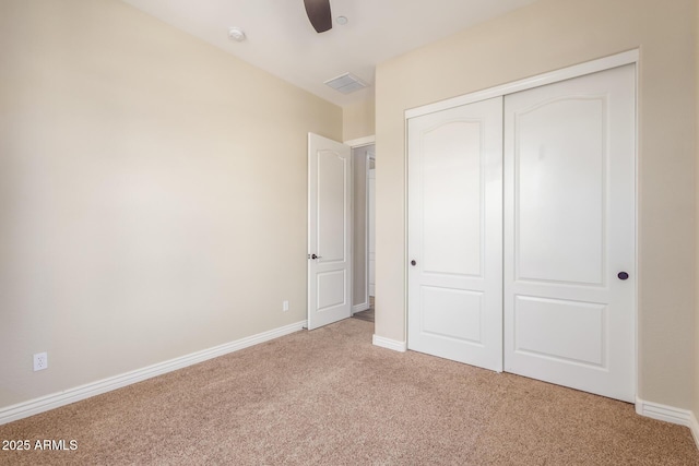 unfurnished bedroom with a closet, light carpet, visible vents, and baseboards