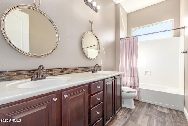 bathroom featuring tasteful backsplash, a sink, toilet, and wood finished floors