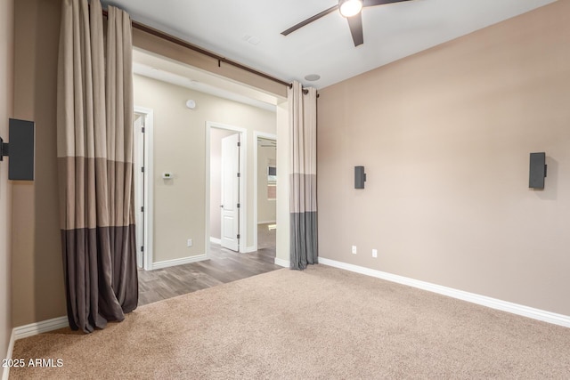 spare room featuring ceiling fan, carpet, and baseboards