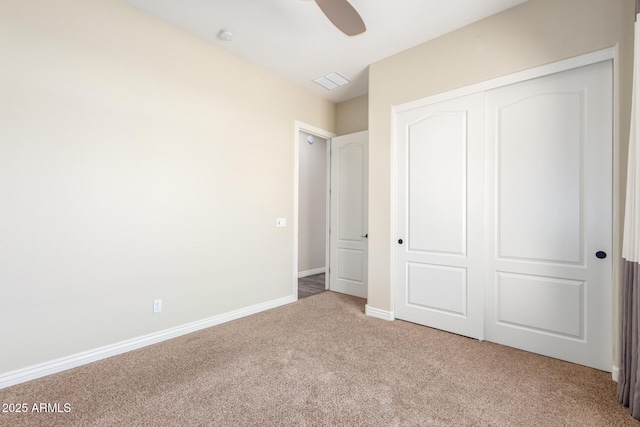 unfurnished bedroom with carpet flooring, visible vents, a ceiling fan, baseboards, and a closet