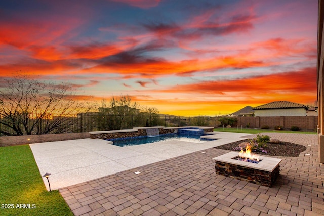 view of pool with a patio area, a fenced backyard, a pool with connected hot tub, and an outdoor fire pit