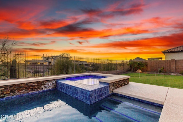 pool at dusk featuring a fenced backyard and an in ground hot tub