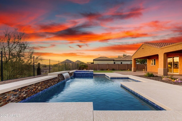 view of swimming pool featuring a pool with connected hot tub, a fenced backyard, and a patio