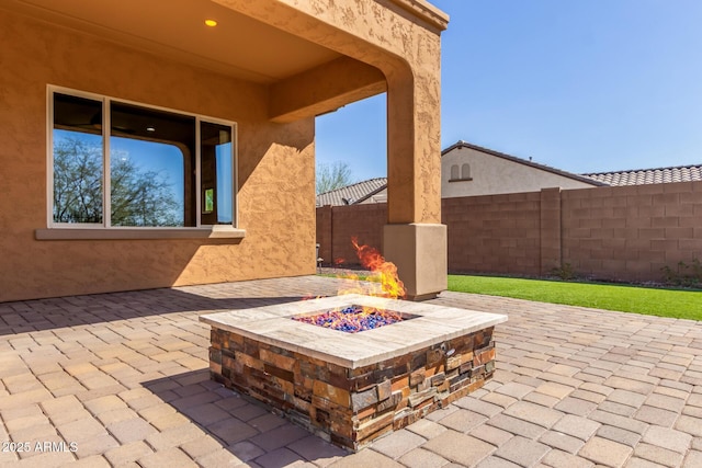 view of patio / terrace featuring an outdoor fire pit and a fenced backyard