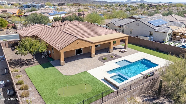 view of swimming pool featuring a patio area, a fenced backyard, a residential view, and a pool with connected hot tub