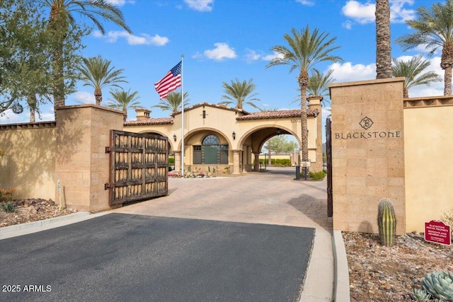 view of street featuring driveway and a gate