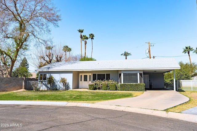 ranch-style home with concrete driveway, fence, a front lawn, a carport, and stucco siding