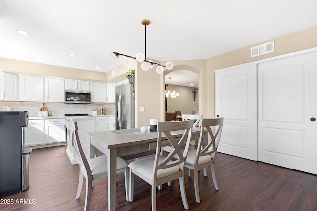 dining room with dark hardwood / wood-style flooring and a notable chandelier