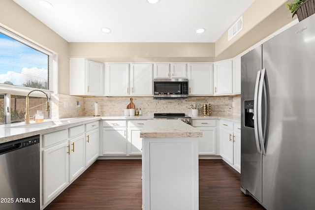 kitchen with sink, white cabinetry, tasteful backsplash, a center island, and appliances with stainless steel finishes