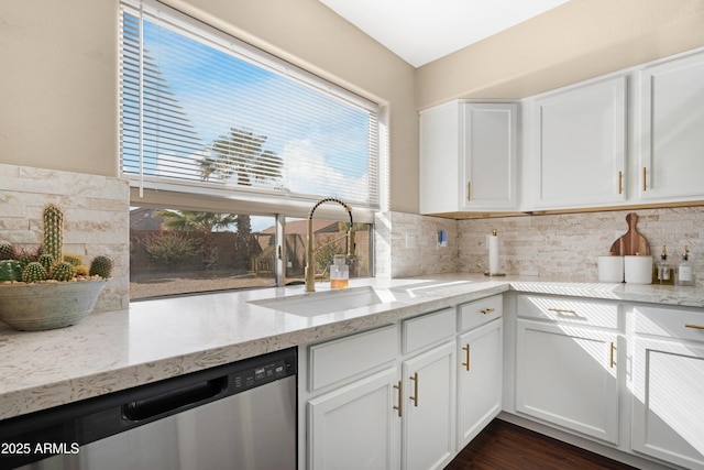 kitchen featuring sink, light stone counters, white cabinetry, dishwasher, and backsplash