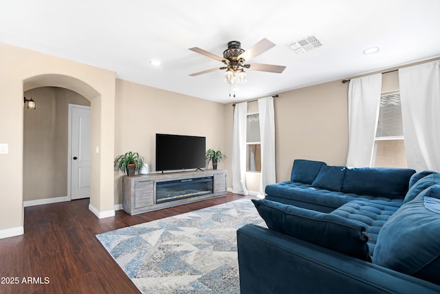 living room featuring ceiling fan and dark hardwood / wood-style flooring