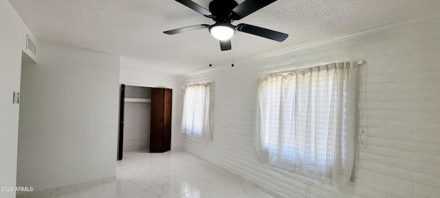 tiled spare room with a textured ceiling and visible vents