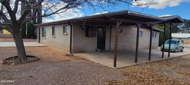 view of property exterior featuring a patio area and brick siding