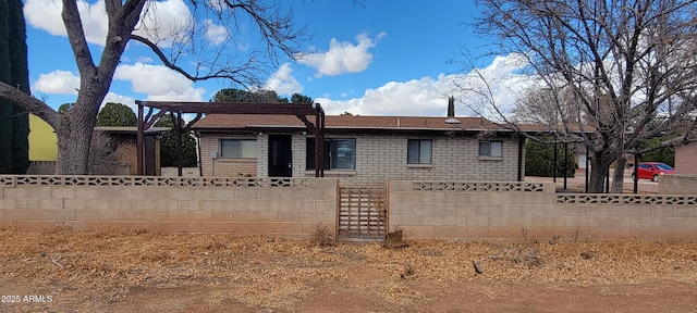 view of front facade featuring brick siding and fence