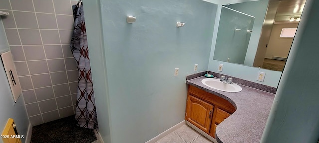 bathroom featuring a baseboard radiator, vanity, tiled shower, and tile patterned floors