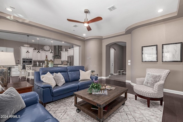 living room with ceiling fan, wine cooler, and light hardwood / wood-style flooring