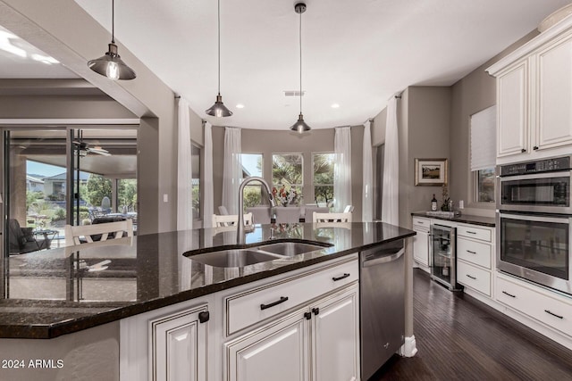 kitchen with beverage cooler, a healthy amount of sunlight, sink, and appliances with stainless steel finishes