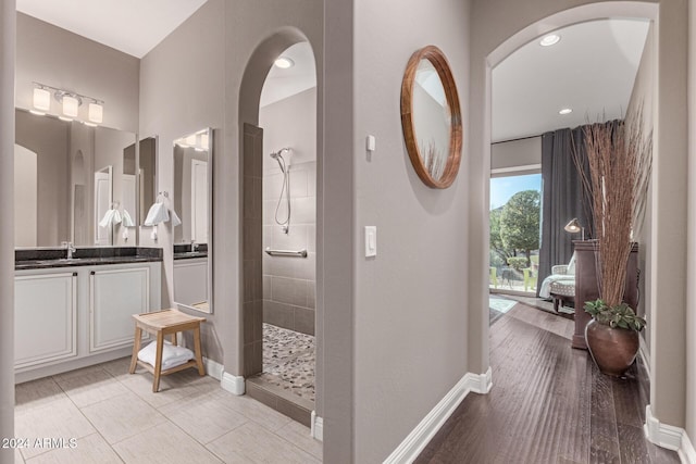 bathroom featuring tiled shower, vanity, and hardwood / wood-style flooring