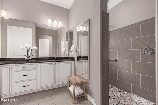 bathroom with tiled shower and vanity