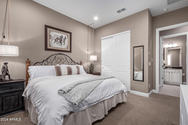 carpeted bedroom featuring ensuite bath and a closet