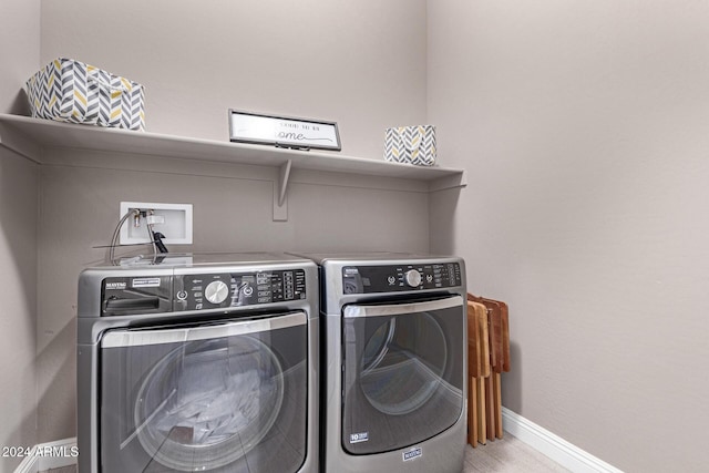 clothes washing area featuring washer and clothes dryer