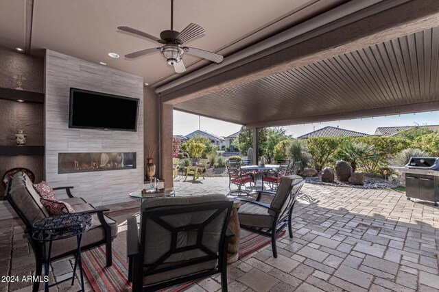 view of patio featuring an outdoor living space with a fireplace and ceiling fan