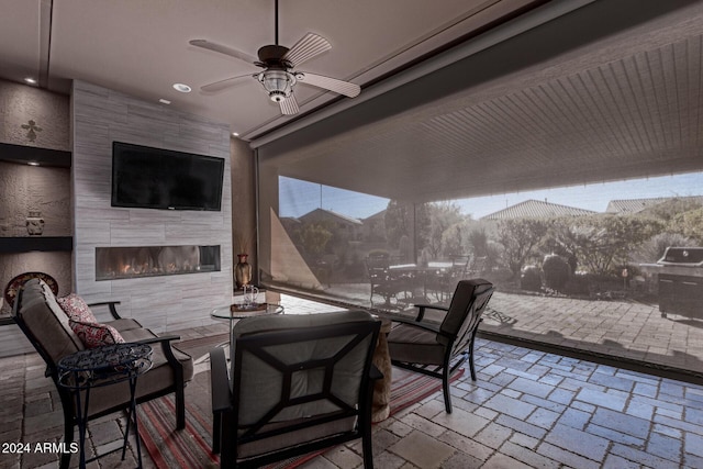 view of patio / terrace with a fireplace and ceiling fan