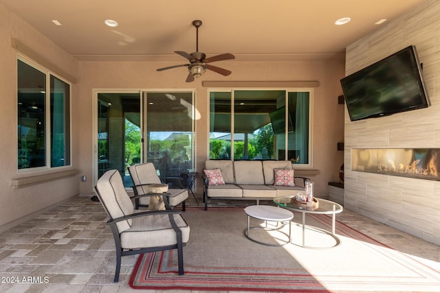 view of patio / terrace featuring an outdoor living space with a fireplace and ceiling fan