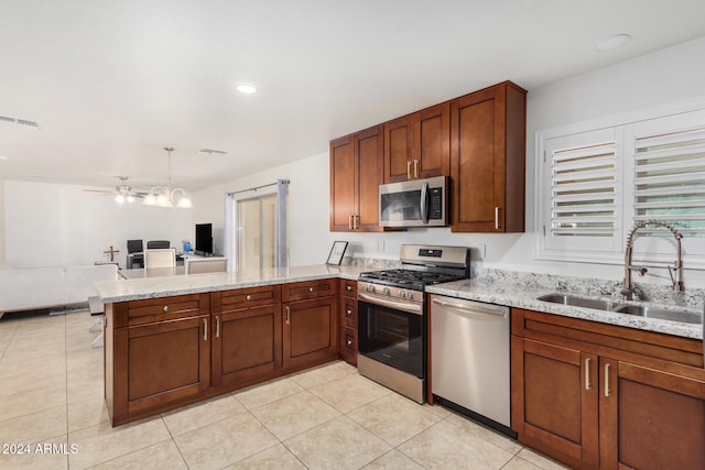 kitchen with stainless steel appliances, visible vents, open floor plan, a sink, and a peninsula