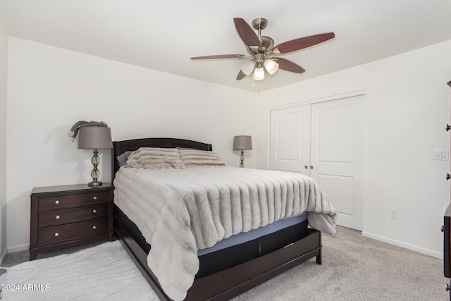 bedroom featuring light carpet, a closet, a ceiling fan, and baseboards