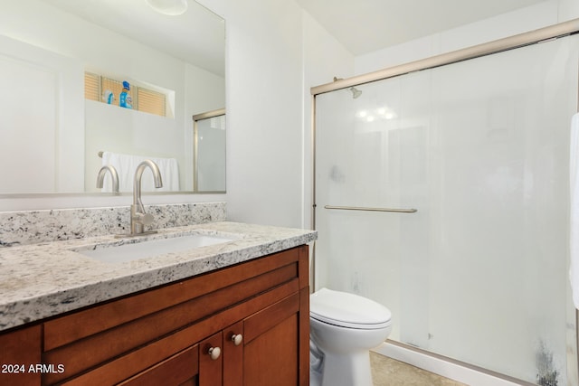 bathroom featuring a stall shower, vanity, and toilet