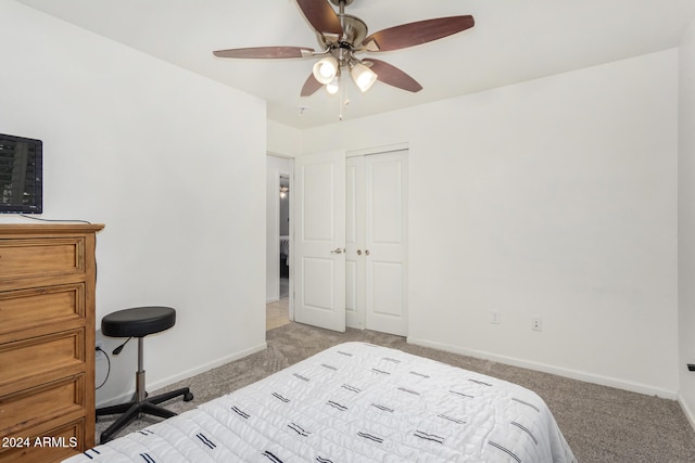 bedroom featuring baseboards, ceiling fan, a closet, and light colored carpet