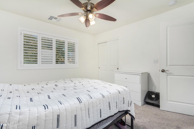 bedroom with ceiling fan, visible vents, a closet, and light colored carpet