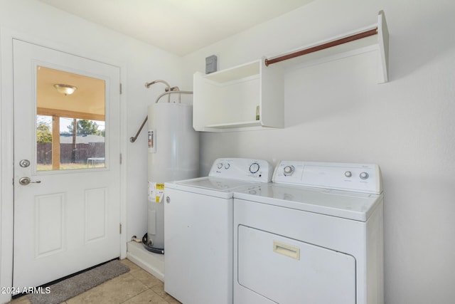 laundry room featuring light tile patterned floors, laundry area, electric water heater, and washer and dryer